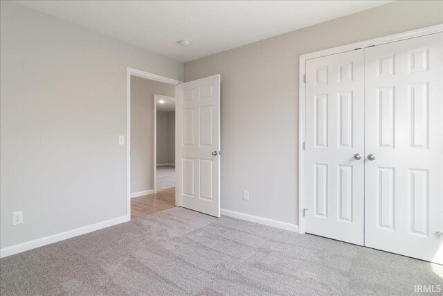 unfurnished bedroom featuring a closet, carpet, and baseboards