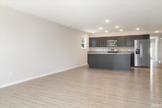 kitchen featuring light wood-style floors, baseboards, and appliances with stainless steel finishes