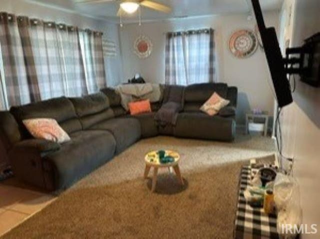 living room featuring ceiling fan and tile patterned floors