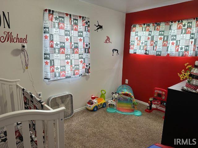 carpeted bedroom featuring a crib