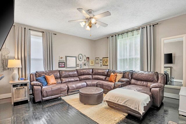 living room with a textured ceiling, ceiling fan, and dark hardwood / wood-style flooring