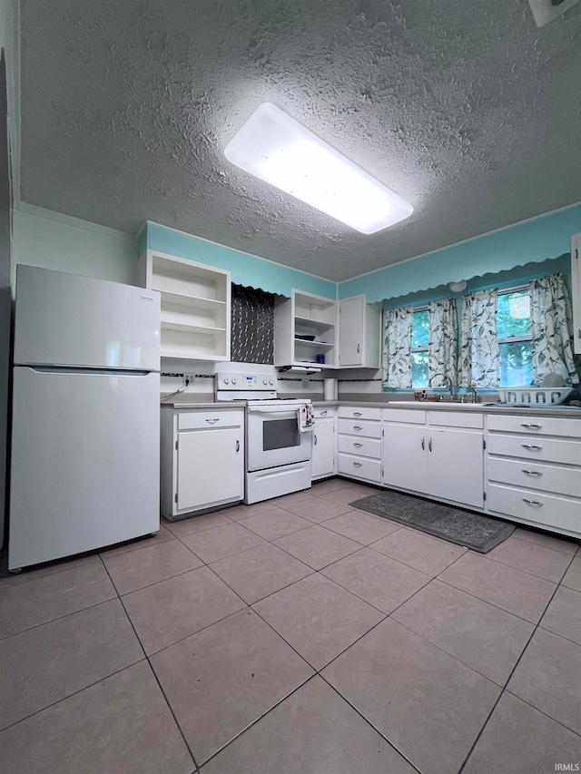 kitchen with white cabinets, a textured ceiling, white appliances, and light tile patterned floors