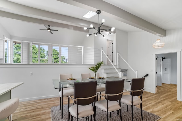 dining space featuring beam ceiling, light hardwood / wood-style flooring, and ceiling fan with notable chandelier