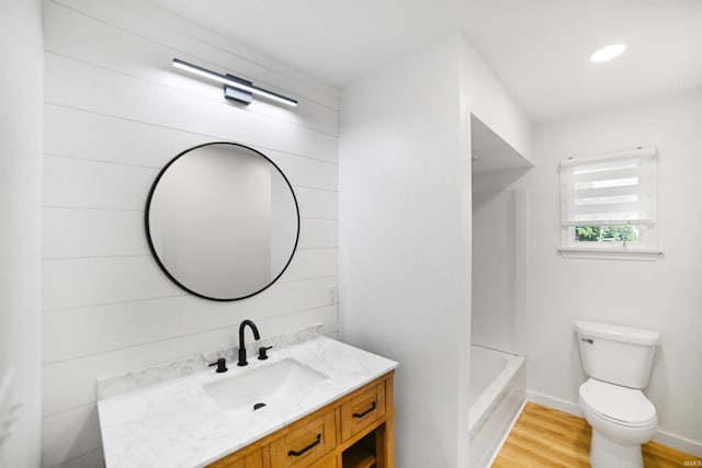 full bathroom featuring hardwood / wood-style flooring, toilet, shower / tub combination, and vanity