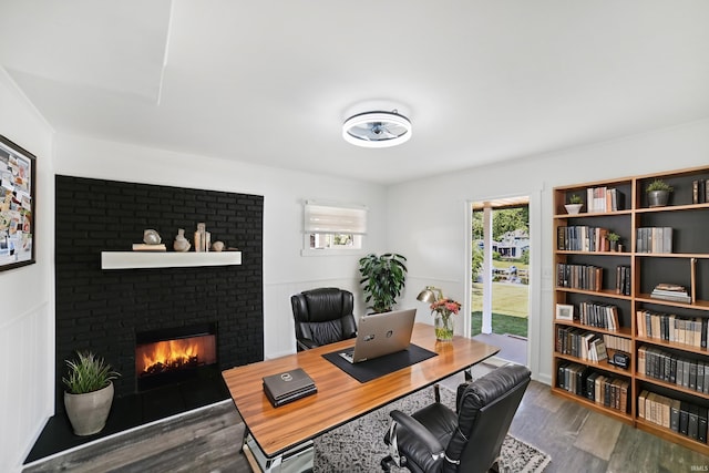 office space featuring a brick fireplace and hardwood / wood-style floors