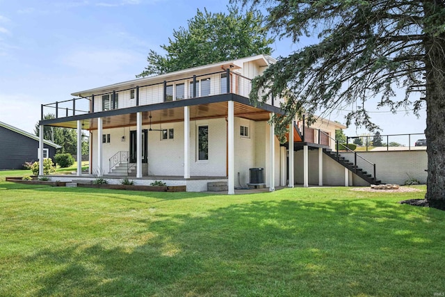 back of house featuring central air condition unit and a yard