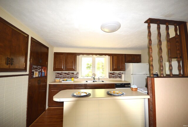 kitchen with sink, dishwasher, hardwood / wood-style floors, and white refrigerator