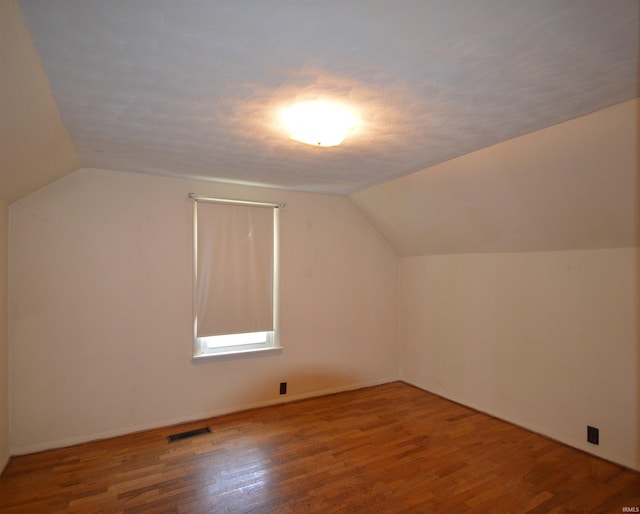 additional living space with wood-type flooring and lofted ceiling