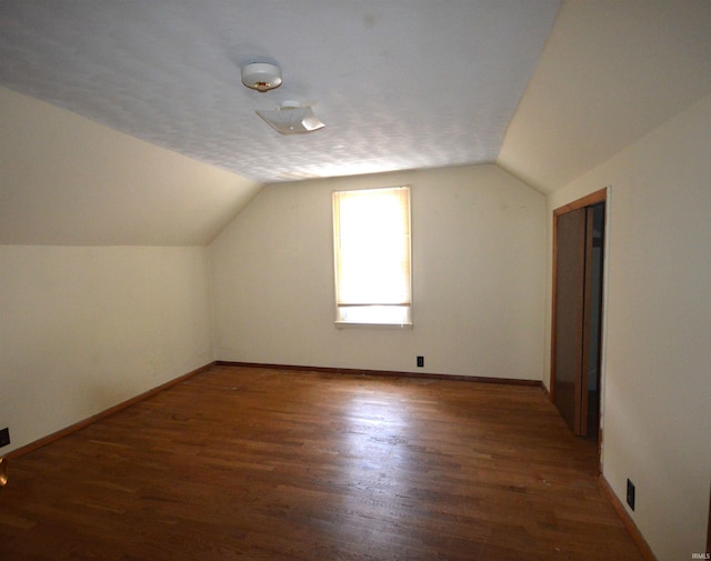 bonus room with wood-type flooring, a textured ceiling, and lofted ceiling