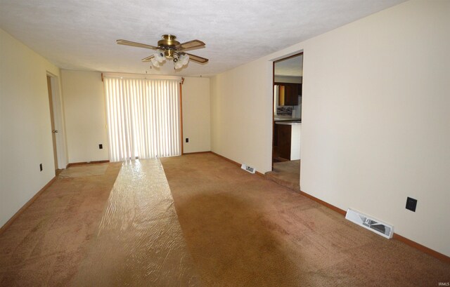 spare room featuring ceiling fan and light carpet