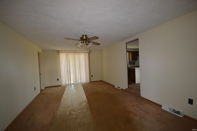 carpeted spare room featuring ceiling fan