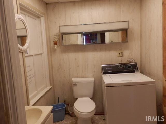 bathroom featuring tile patterned flooring, toilet, washer / dryer, and vanity