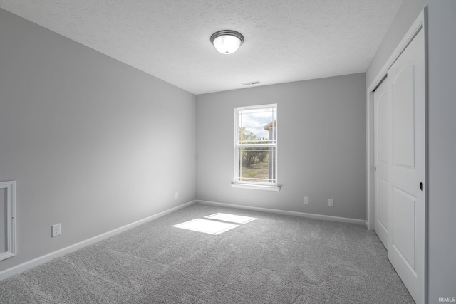 unfurnished bedroom featuring carpet floors, a closet, visible vents, and baseboards