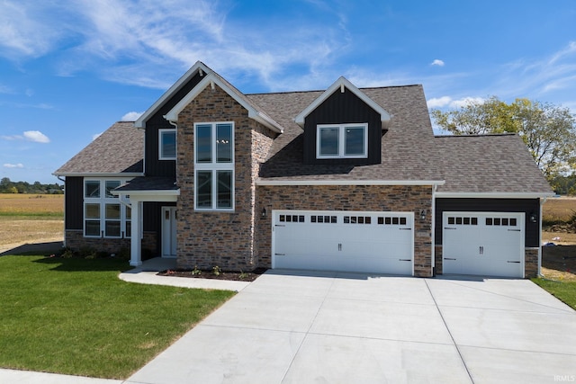 view of front of house with roof with shingles, board and batten siding, a front yard, a garage, and driveway