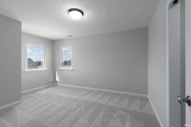 unfurnished room featuring visible vents, baseboards, and carpet flooring