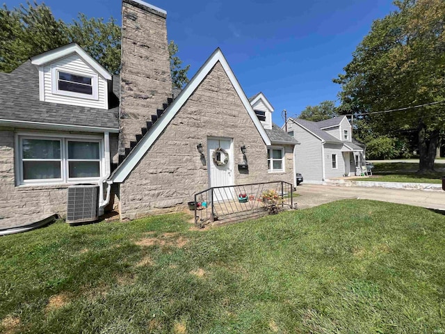 view of front of home featuring central AC unit and a front lawn