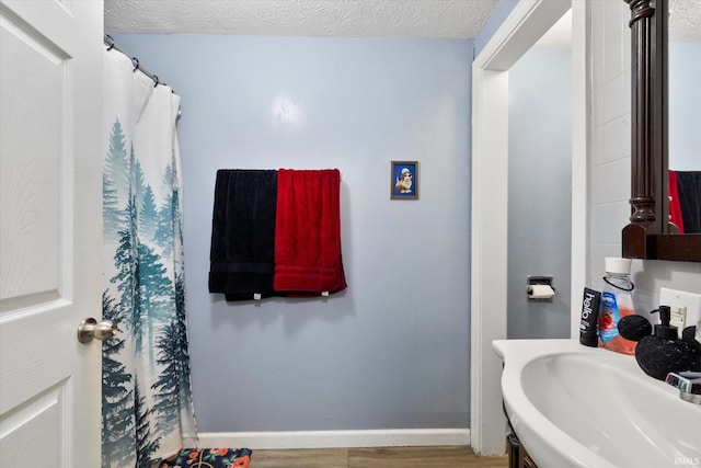 bathroom featuring sink, a textured ceiling, and hardwood / wood-style flooring