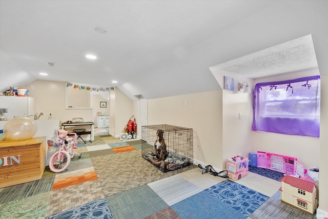 game room featuring a textured ceiling, vaulted ceiling, and light colored carpet