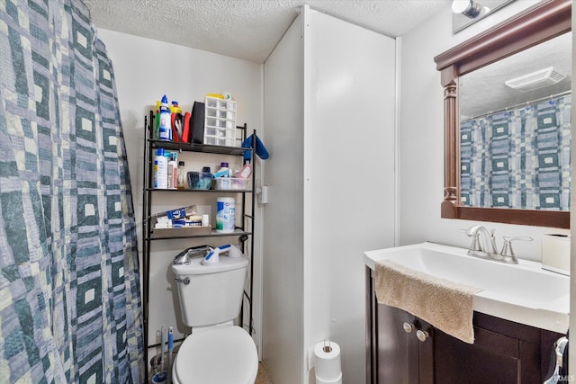 bathroom featuring a textured ceiling, toilet, and vanity