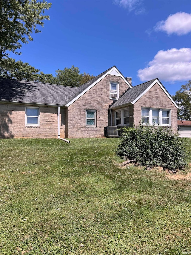 view of front of property with cooling unit and a front yard