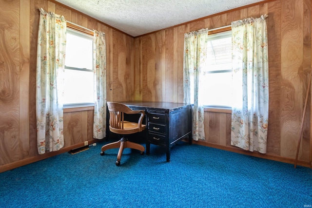 home office featuring crown molding, a wealth of natural light, wood walls, and a textured ceiling