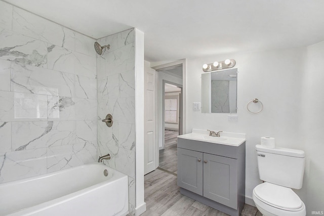 full bathroom featuring toilet, tiled shower / bath, hardwood / wood-style flooring, and vanity