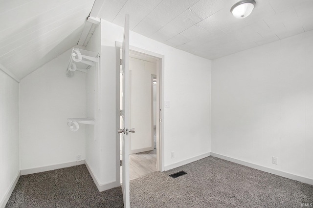 interior space with carpet floors and vaulted ceiling