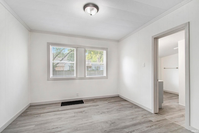 empty room with crown molding and light hardwood / wood-style floors