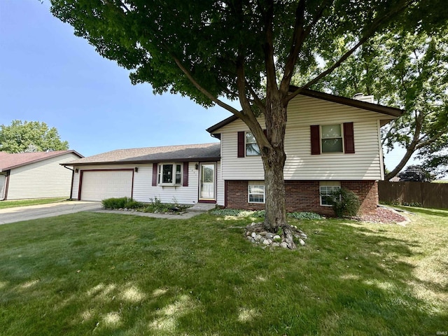 split level home featuring brick siding, fence, a garage, driveway, and a front lawn