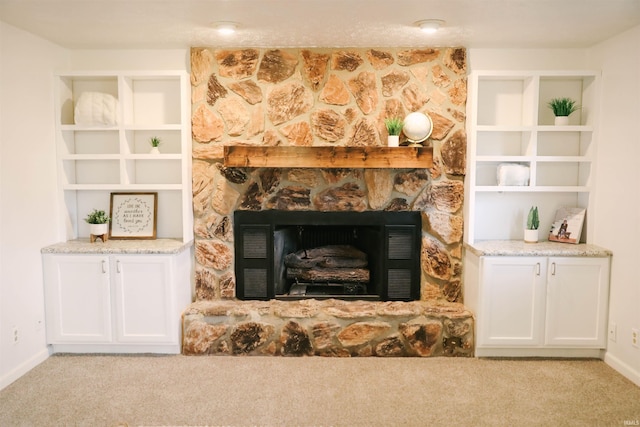 interior space with carpet floors, baseboards, and a stone fireplace