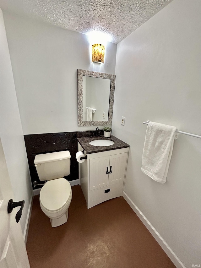 bathroom featuring baseboards, toilet, a textured ceiling, and vanity