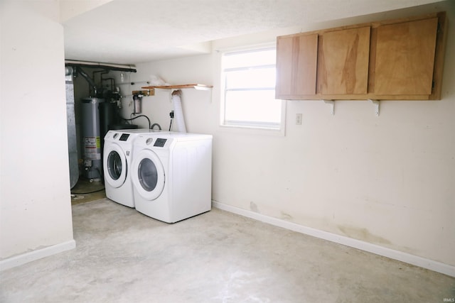 clothes washing area with cabinet space, washing machine and dryer, baseboards, and gas water heater