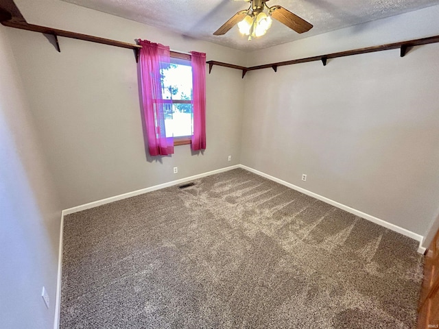 carpeted spare room featuring a ceiling fan, visible vents, a textured ceiling, and baseboards