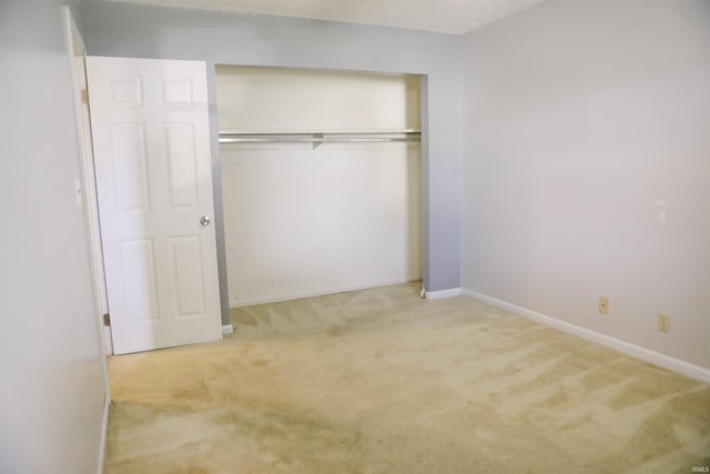 unfurnished bedroom with a closet, carpet flooring, and baseboards