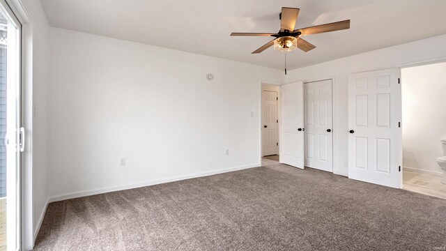 unfurnished bedroom with connected bathroom, ceiling fan, and carpet flooring