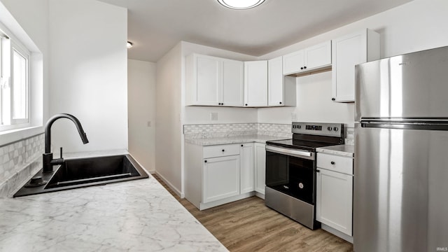 kitchen featuring light hardwood / wood-style flooring, stainless steel appliances, sink, and white cabinets