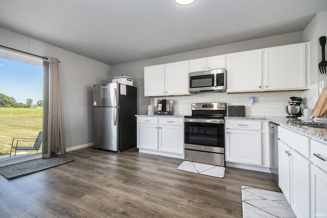 kitchen featuring stainless steel appliances, dark wood-type flooring, decorative backsplash, and white cabinets