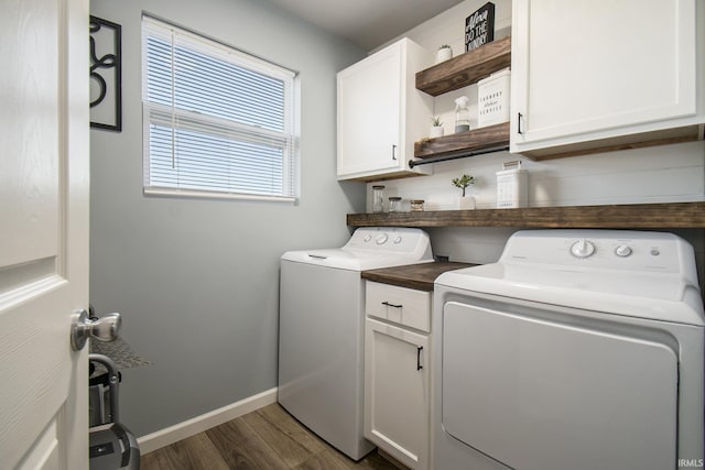 washroom featuring cabinet space, baseboards, dark wood-type flooring, and washer and dryer