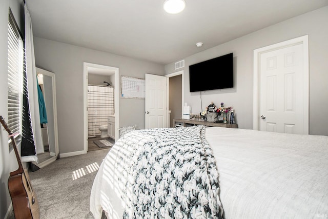 carpeted bedroom with visible vents, connected bathroom, and baseboards