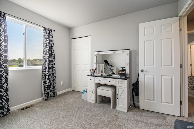 bedroom with baseboards, visible vents, and light colored carpet