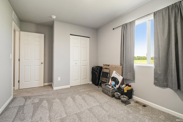 bedroom with baseboards, a closet, visible vents, and light colored carpet