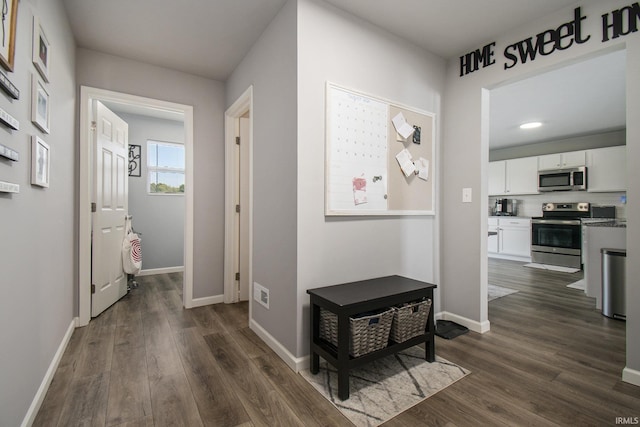 hallway with dark wood-style flooring and baseboards