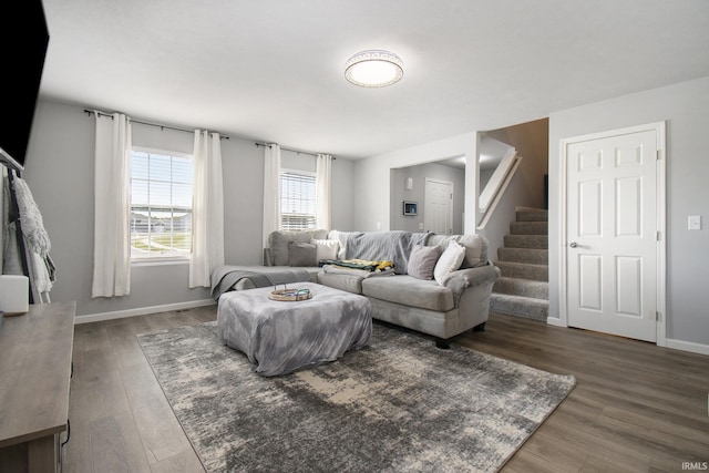 living area featuring dark wood finished floors, stairway, and baseboards