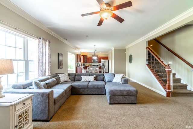 living room featuring ceiling fan, ornamental molding, and light colored carpet