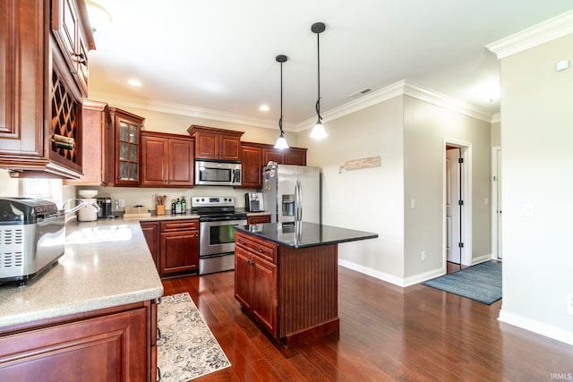 kitchen with dark stone countertops, appliances with stainless steel finishes, dark hardwood / wood-style floors, a kitchen island, and crown molding