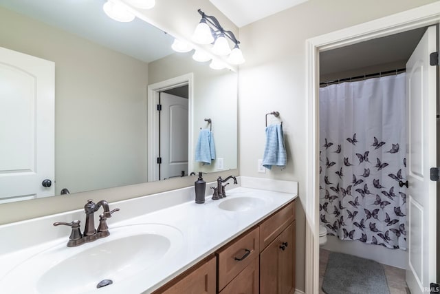 bathroom featuring toilet, vanity, and curtained shower