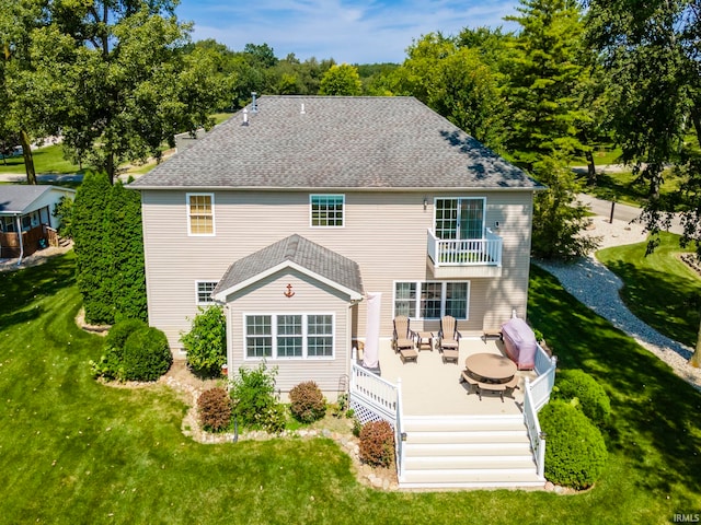 rear view of house with a deck and a yard