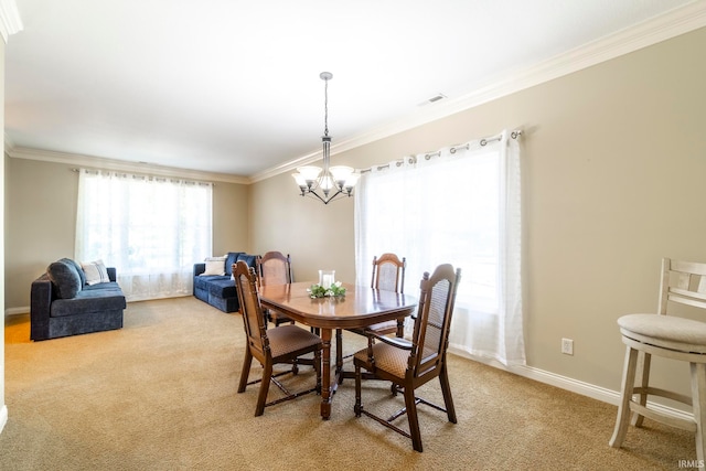 carpeted dining space featuring a chandelier and ornamental molding