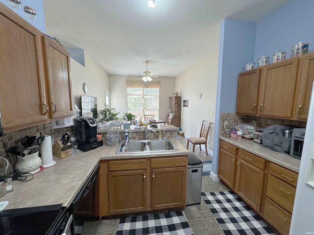 kitchen featuring tasteful backsplash, light countertops, a sink, dishwasher, and a peninsula