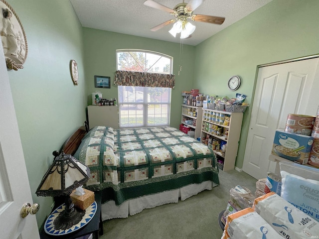 carpeted bedroom featuring a ceiling fan and a textured ceiling